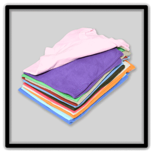 Layered stack of folded vintage blank T-shirts with pink and purple shirts on top.