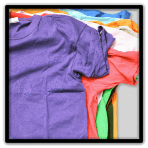 Close-up of layered colorful vintage T-shirts with a purple shirt across the front.